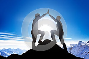 Male Friends Giving High Five On Mountain Peak