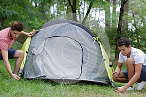 male friends setting up tent outdoors