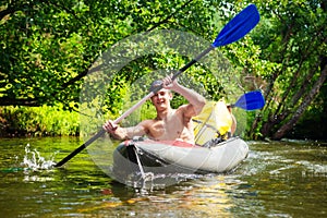Male friends swim in kayak on wild river in summer