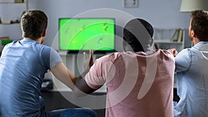 Male friends watching football match on TV, fans supporting national team
