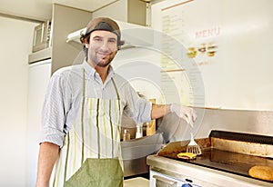 Male fry cook frying a fresh hamburger patty with cheese