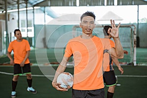 male futsal players standing poses with an ok hand gesture