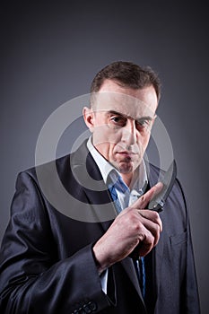 Male gangster in a business suit with a knife