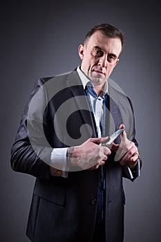 Male gangster in a business suit with a knife