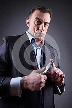 Male gangster in a business suit with a knife