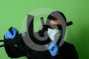 Male gangster or criminal in a medical surgical mask and sunglasses dressed in black clothes