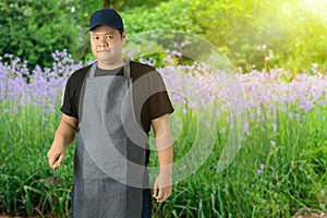 Male gardener hand holding garden tools and blurred background is flower garden