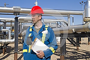 Male gas field operator inspects compressor site