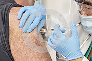 Male getting a vaccine administered by a doctor