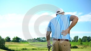 Male golf player feeling strong lower back pain after ball hitting, trauma