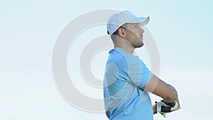 Male golf player making half-swing and hitting ball, enjoying good accurate shot