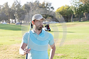 male golf player on professional golf course. portrait of golfer in cap with golf club.