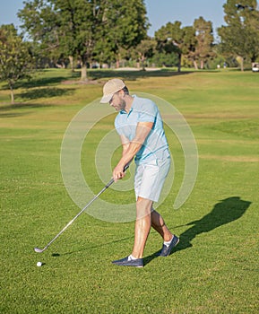 male golf player on professional golf course. portrait of golfer in cap with golf club