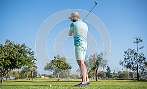 male golf player on professional golf course. portrait of golfer in cap with golf club.