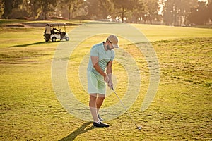 male golf player on professional golf course. portrait of golfer in cap with golf club.