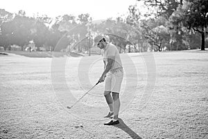 male golf player on professional golf course. portrait of golfer in cap with golf club.