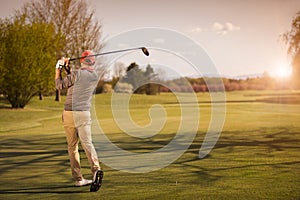 Male golf player at sunset.