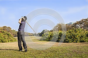 Male golf player teeing off golf ball from tee box