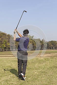 Male golf player teeing off golf ball from tee box