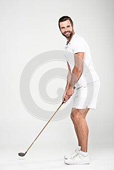 male golf player in white sportswear with golf club,