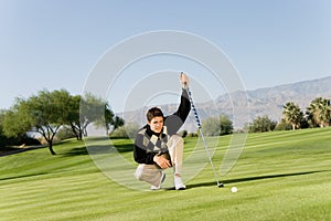 Male Golfer Lining Up Putt