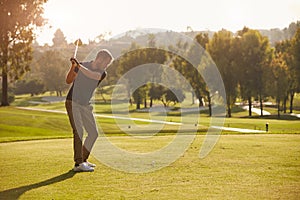 Male Golfer Lining Up Tee Shot On Golf Course