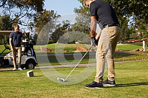 Male Golfer Lining Up Tee Shot On Golf Course
