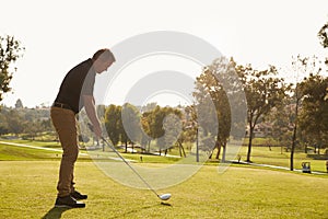 Male Golfer Lining Up Tee Shot On Golf Course