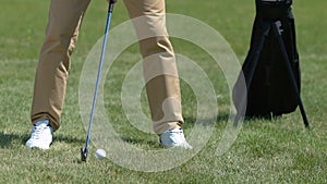 Male golfer making half-swing to land ball safely on green near hole, strategy