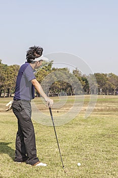 Male golfer player teeing off golf ball from tee box