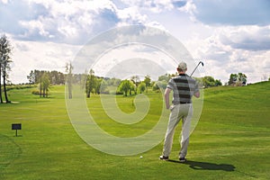 Male golfer standing at fairway on golf course