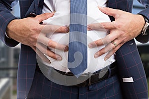 Male grabbing bloated abdomen as indigestion problem photo