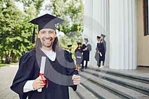 Male graduate is smiling against the background of university graduates.