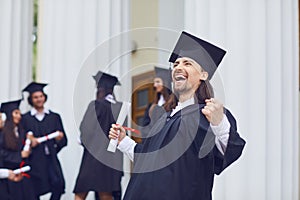 Male graduate is smiling against the background of university graduates.