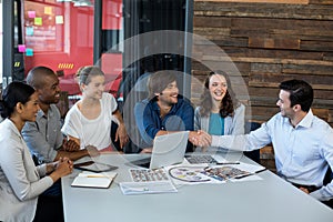 Male graphic designer shaking hands with his colleague