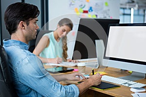 Male graphic designer using graphics tablet at desk