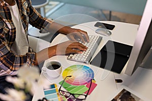 Male graphic designer working on computer at desk in office