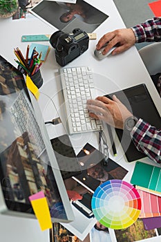 Male graphic designer working on computer at desk in office