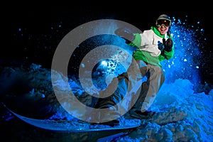 Male in green jacket rides on a snowboard