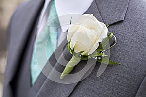 Male in grey suit with white rose