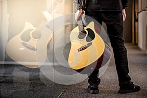 Male guitarist holding acoustic guitar