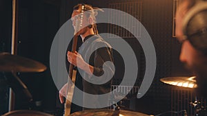 Male guitarist plays the electric guitar in music recording room