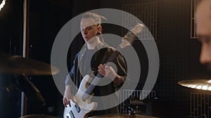 Male guitarist plays the electric guitar in music recording room