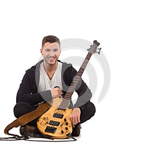 Male guitarist sitting on the floor.