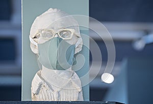 Male gypsum bust wearing a turquoise facial mask