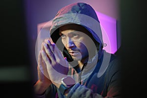 Male hacker in hoodie using computer for attack security to data digital internet network system. Cybersecurity concept