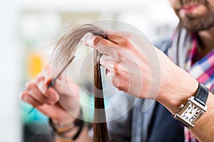 Male hairdresser cutting woman hair in hairdresser shop