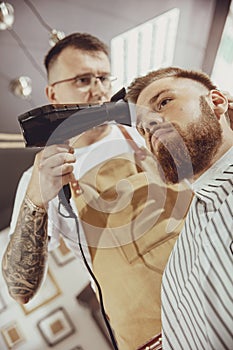 Male hairdresser dries hair of his client photo