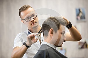 Male hairdresser making haircut photo