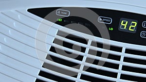 Male hand adjusting settings on an evaporative humidifier, climate control